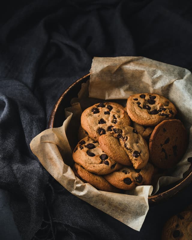 Chocolate chip cookies opgestapeld in een mandje met bakpapier